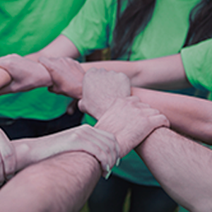 Fondo de solidaridad - Personas agarradas de la mano con camiseta verde